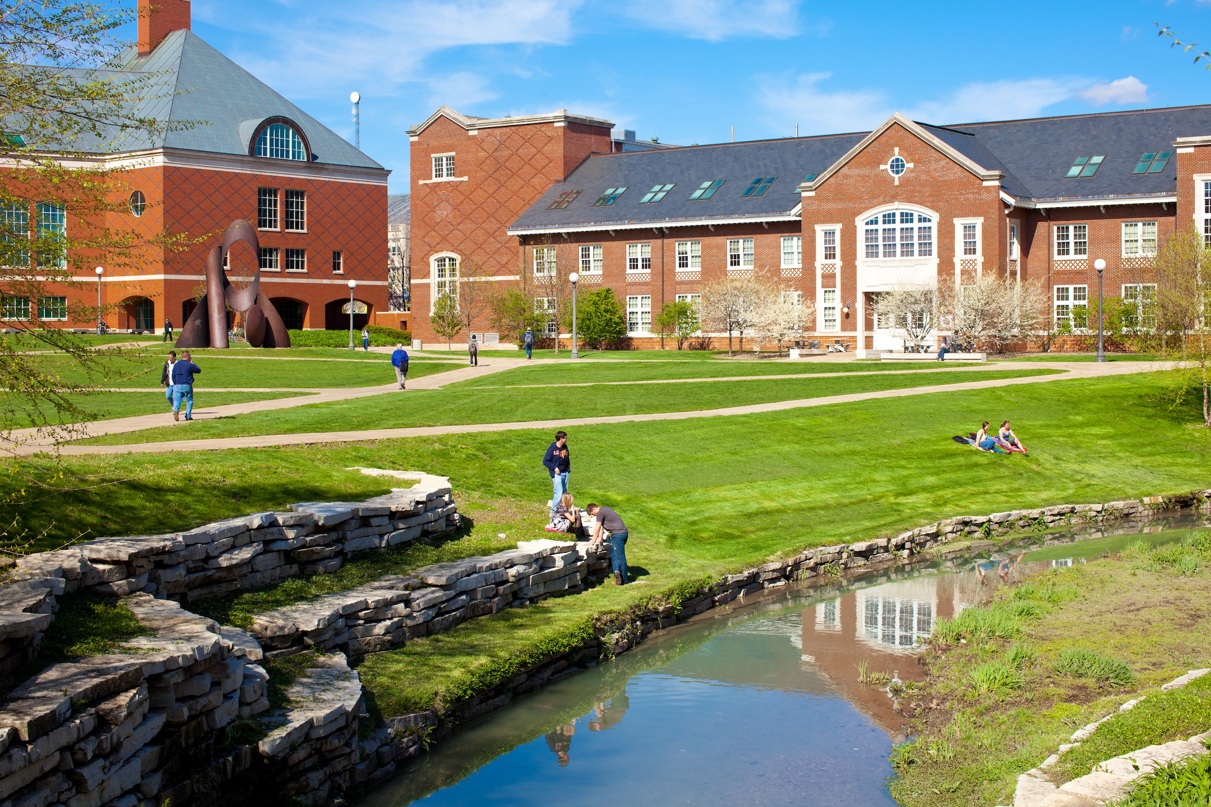 A sunny view of buildings and a stream on the UIUC campus